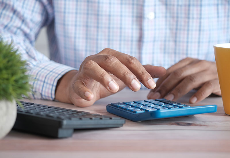 person using calculator to calculate tax bills
